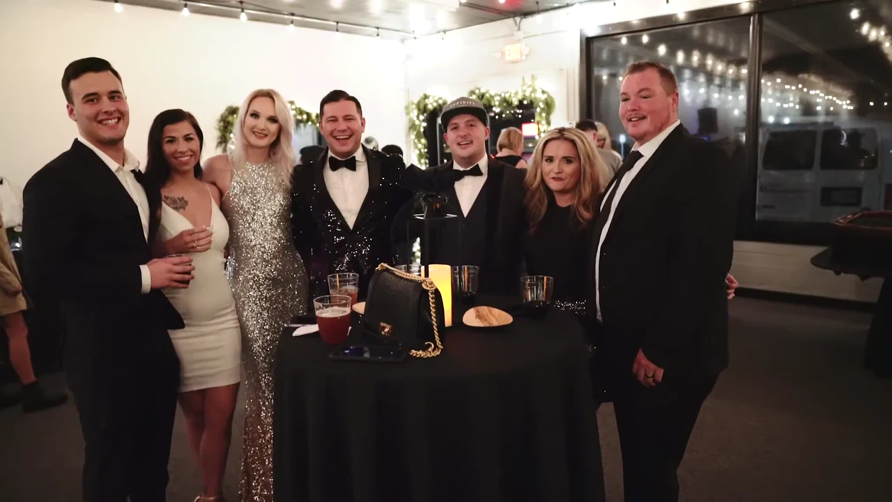 A formally dressed group poses together during an evening event